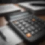 A calculator with tax forms and a pen on a desk